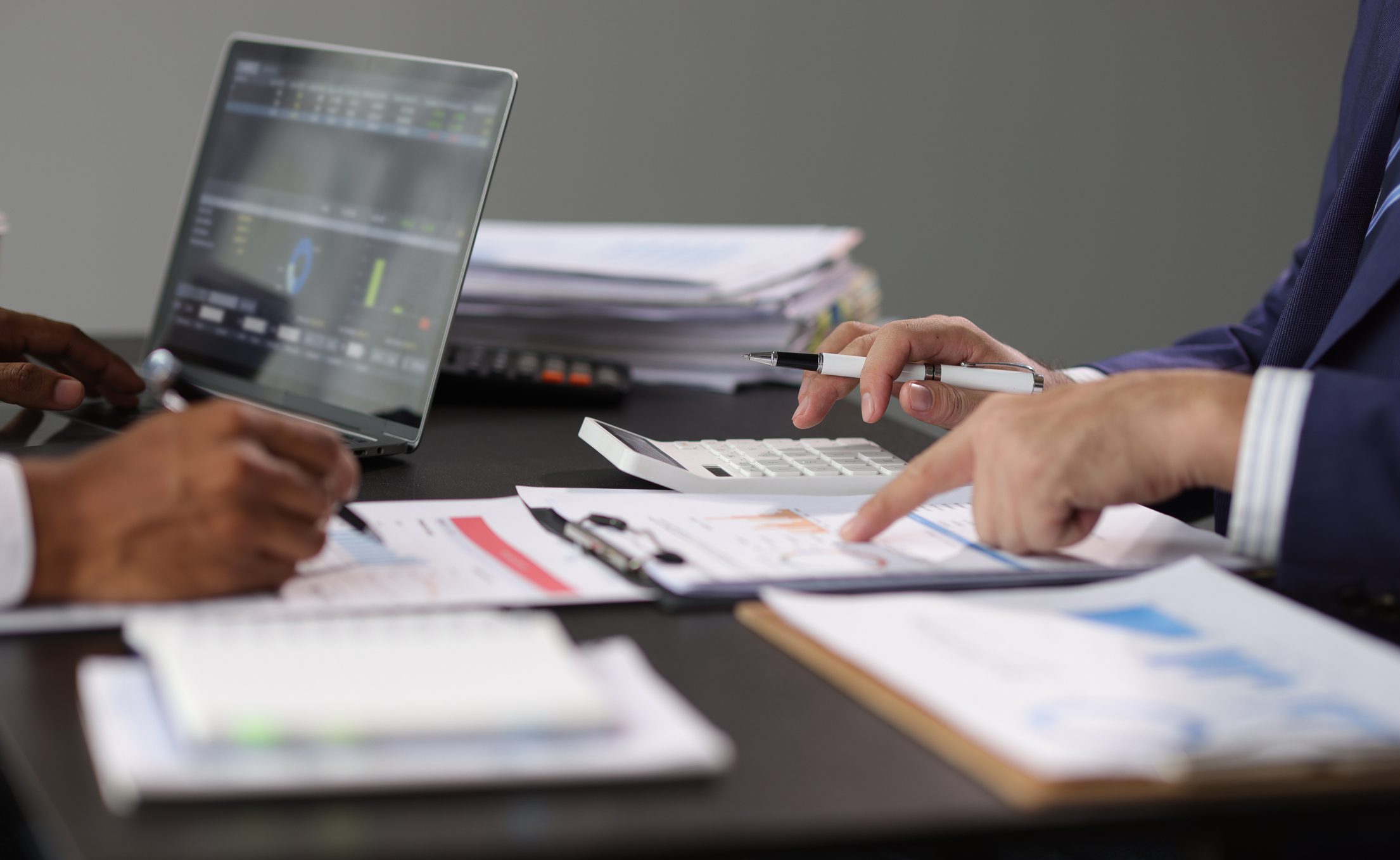 Hands pointing at financial documents and calculator