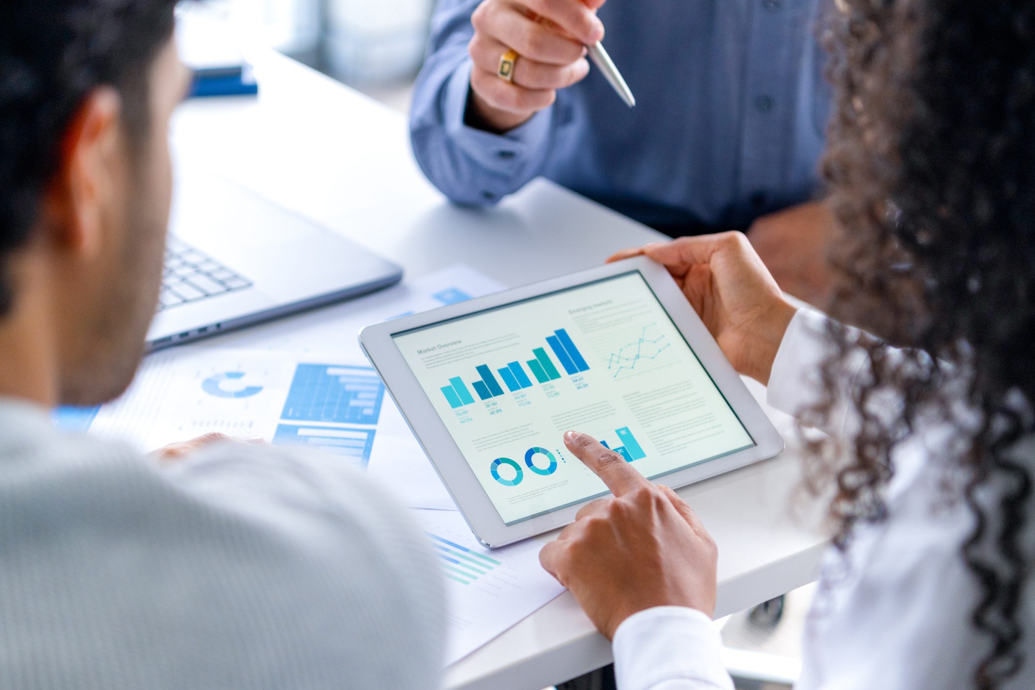 Colleagues analyzing business charts on tablet