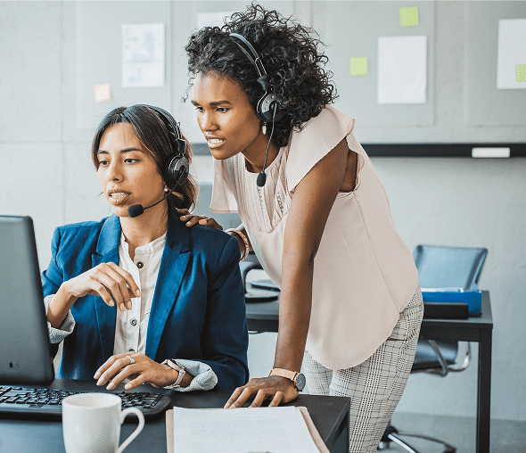 Two customer service agents collaborating at computer